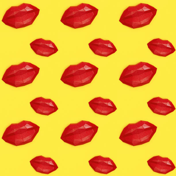 istock Seamless pattern with bright beauty red polygonal paper lips on yellow background. 1255158397