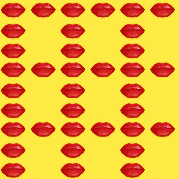 istock Seamless pattern with bright beauty red polygonal paper lips on yellow background. 1255158404