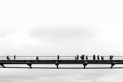 London, UK, 09/05/2012: tourists on the Millennium Bridge to visit museums and the city centre of London, travel reportage