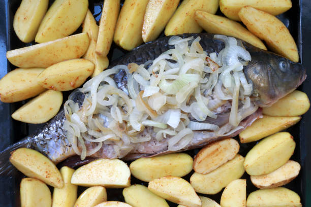 istock Fresh carp with onions and potatoes 1255164696