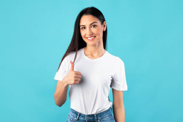 istock Young lady showing thumb up and smiling 1255164976