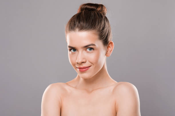 istock Closeup of nude young model posing over grey background 1255165024