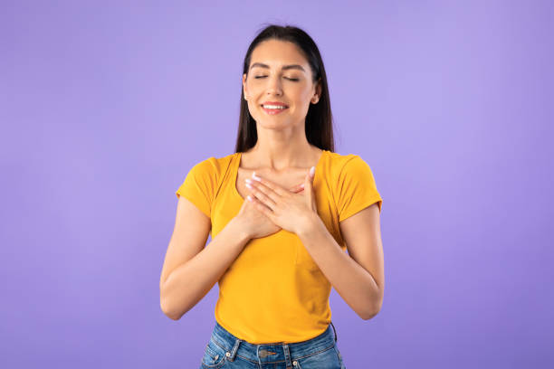 istock Happy woman posing and keeping hands on chest 1255165216