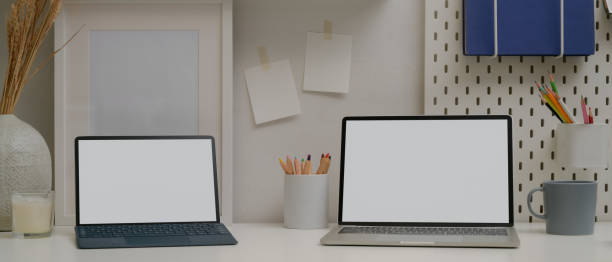 istock Comfortable workspace with mock up laptop, tablet with keyboard, stationery and decorations 1255165920