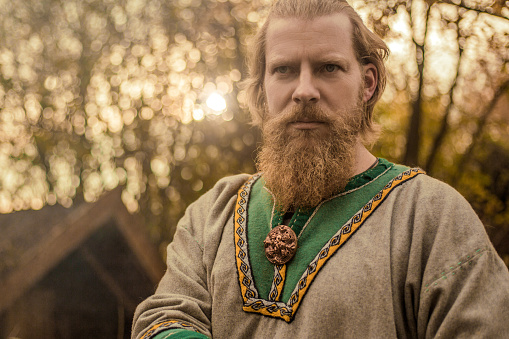 An individual viking man posing for an individual pic in an authentic viking settlement village setting