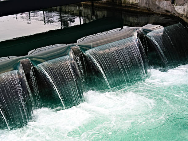 Water flowing over a threshold, at an hydroelectric power station Water of the Reuss River, flowing over a sill, at a hydroelectric power station in the city of Lucerne hydroelectric power photos stock pictures, royalty-free photos & images
