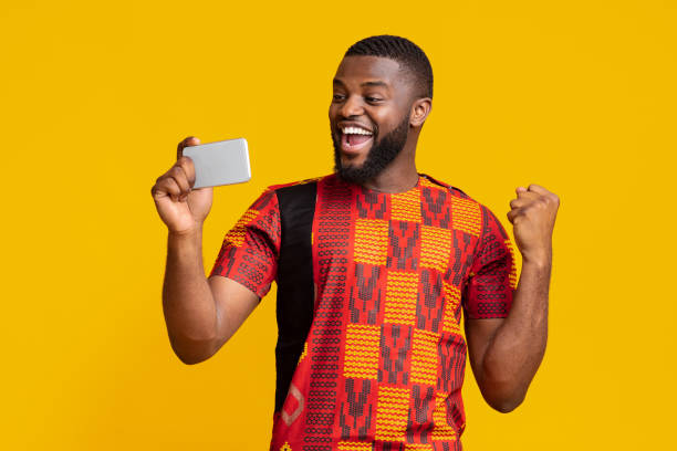 istock Happy black man holding phone and expressing happiness 1255173370