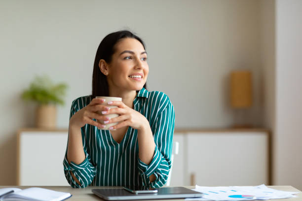 Entrepreneur Woman Smiling Having Coffee At Workplace Sitting In Office
