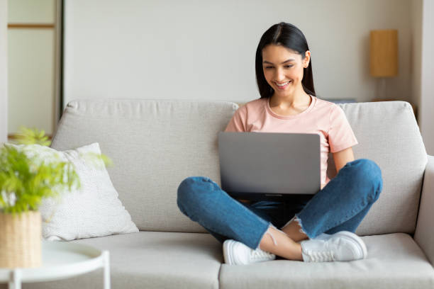 istock Lady Working On Laptop Computer Sitting On Couch At Home 1255177764