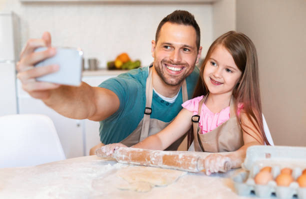 istock Father And Daughter Making Selfie Baking Together At Home 1255178595