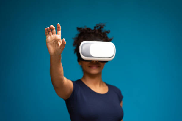 istock Black woman in VR headset pressing button on virtual screen 1255178744