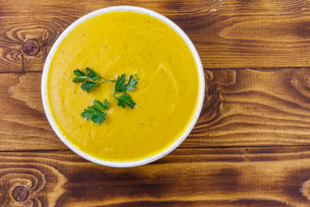 istock Pumpkin soup on a wooden table. Top view 1255178792