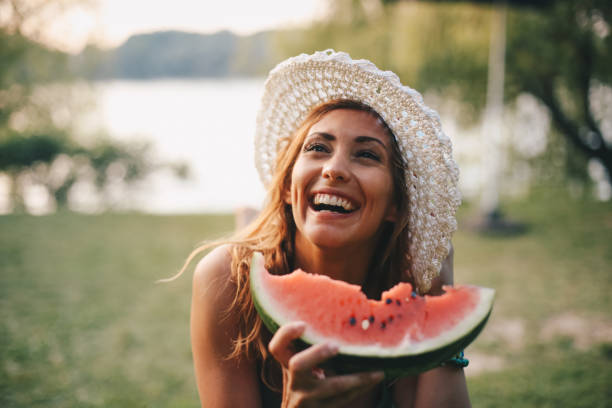 istock A young woman laughs and eats watermelon in nature 1255179055