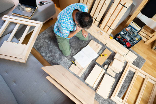 istock Hardworking man assembling wooden furniture 1255180543