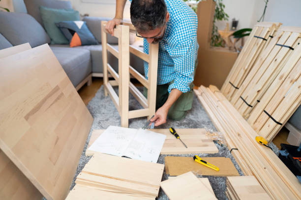 man assembling wooden parts at home - instrument of measurement organization housing project housing development imagens e fotografias de stock