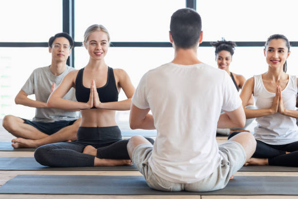 istock Yoga With Instructor. Group Of Young People Practicing Meditation Exercises With Trainer 1255180613