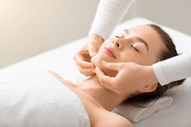 istock Relaxed young lady having lifting face massage at spa 1255180695