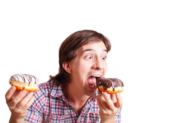 istock Funny man looks at the chocolate doughnut bulging eyes 1255181395