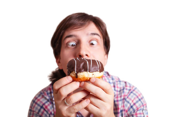 istock Funny man looks at the chocolate doughnut bulging eyes 1255181412