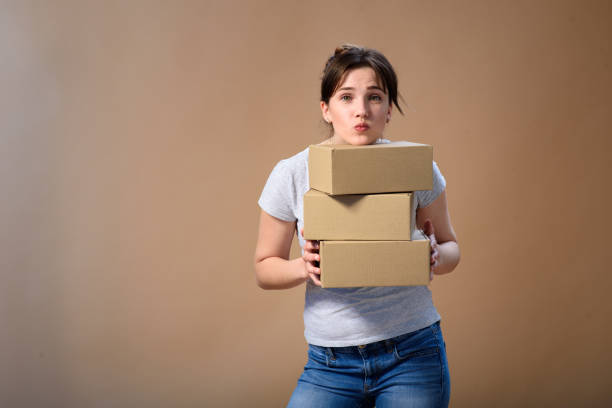 istock The girl laid her head on cardboard boxes on a plain background. 1255181589