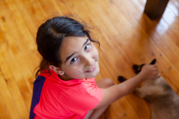 Young girl with pigtails doing the splits, smiling at the camera on white background
