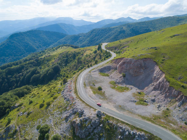 istock Aerial view, drone chasing fast driving red car on mountain winding road 1255185018