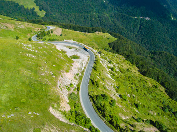 istock truck cargo on mountain passage road with beautiful forest 1255186104