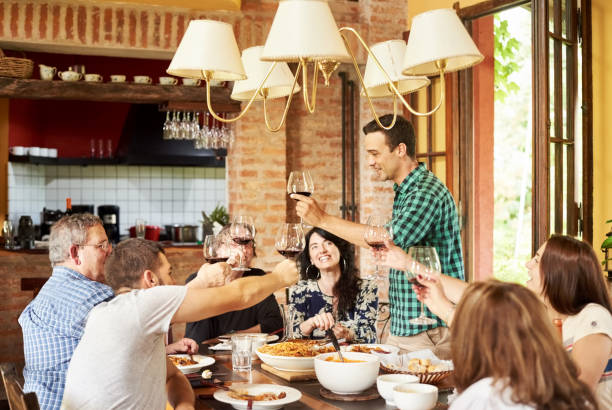 istock Man raising a toast during family lunch 1255186111