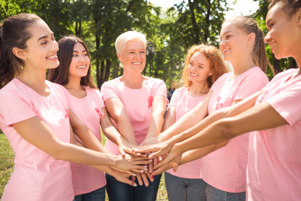istock Women From Breast Cancer Support Group Holding Hands In Park 1255186435