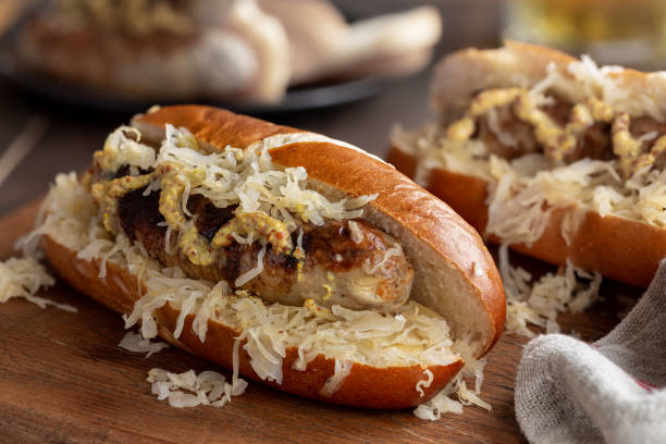 Grilled Bratwurst With Sauerkraut on a Bun Closeup of grilled bratwurst with sauerkraut and dijon mustard on a bun bratwurst stock pictures, royalty-free photos & images