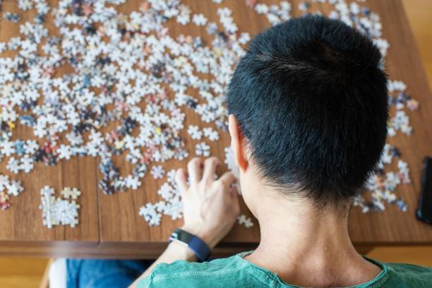 istock Man doing a jigsaw puzzle at home 1255187280