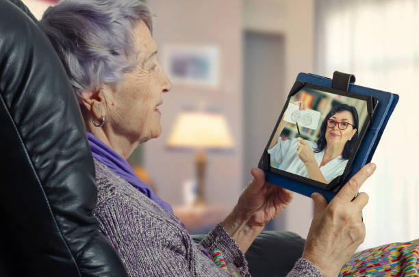 Elderly woman enjoys remote communication with a family doctor (GP) stock photo
