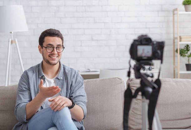 istock Themed blog at home. Guy recording video on camera 1255188347