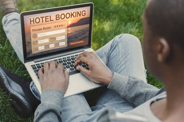 istock Black guy resting at park, booking hotel with laptop 1255188405