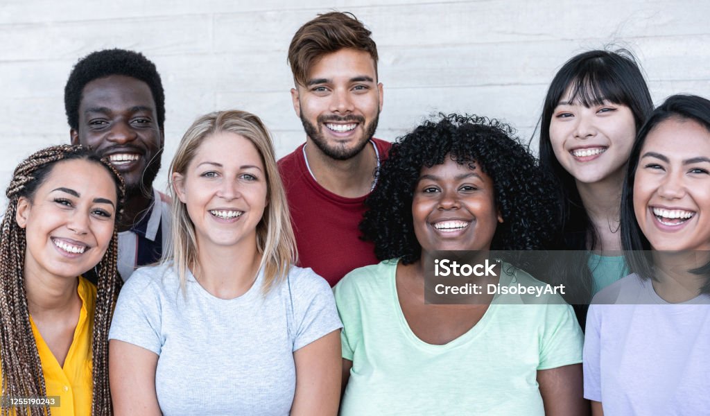 Amigos felices de diferentes razas y cultura riendo frente a la cámara del teléfono - Jóvenes millennials divirtiéndose juntos - Concepto de generación multirracial - Enfoque principal en las chicas del centro - Foto de stock de Grupo multiétnico libre de derechos