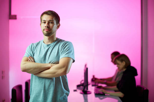 istock Young businessman and his creative design team at the office during developing a new project, pink background 1255194333