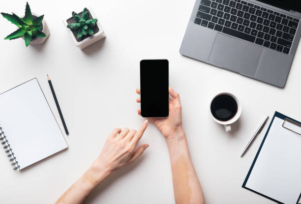 istock Woman hands using cellphone in office, top view, blank screen 1255194808