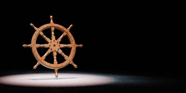 istock Rudder Wheel Spotlighted on Black Background 1255196268