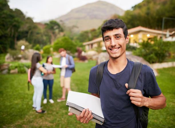 I am ready for the new semester! Single out portrait of a young man at a college campus with his friends standing in background brazilian culture photos stock pictures, royalty-free photos & images