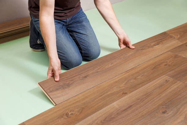 istock Contractor installing laminate floor in new house. 1255196638