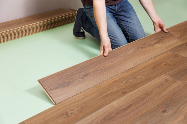 istock Repairman installing new wooden laminate flooring. 1255196696