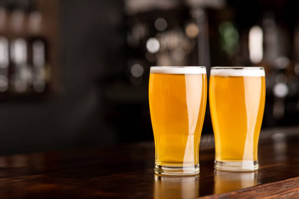 istock Event beer in pub. Two glasses of ale on bar in interior 1255197462
