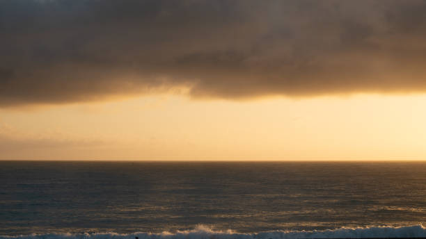 ムーディーな日の出は、穏やかな海と上の3分の1に厚い雲の層で撮影 - marlborough region sunrise new zealand sea ストックフォトと画像