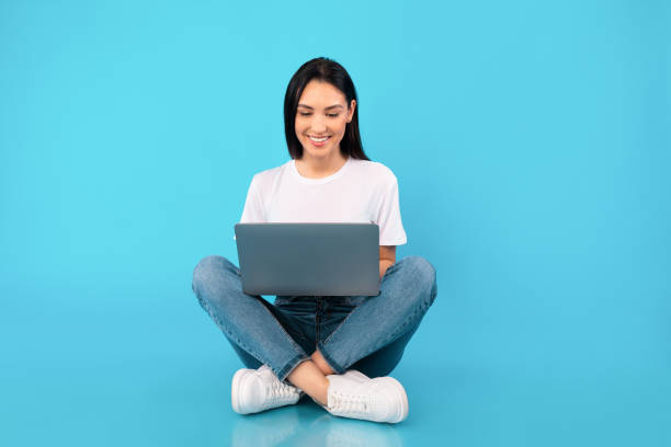 istock Happy lady sitting with laptop at studio 1255197872