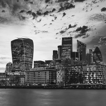 Long exposure, London futuristic skyscrapers overlooking River Thames UK.