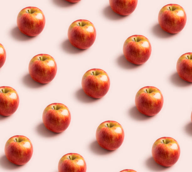 istock Apple minimal pattern at soft pink background. Concept of harvest raw food 1255202107