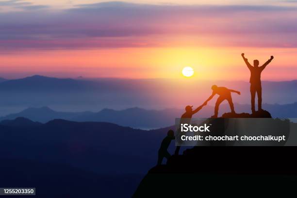 Teamwork Friendship Hiking Help Each Other Trust Assistance Silhouette In Mountains Sunrise Teamwork Of Two Men Hiker Helping Each Other On Top Of Mountain Climbing Team Beautiful Sunrise Landscape Stock Photo - Download Image Now