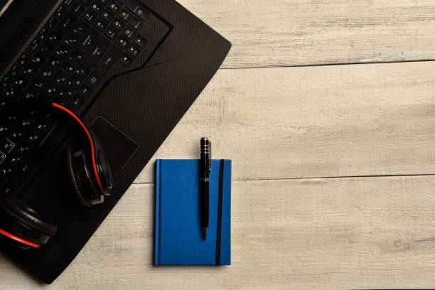 istock Laptop, notebook and headphones  lie on a wooden table 1255203443