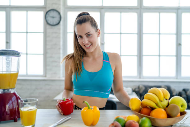 istock Young woman making detox smoothie at home 1255204624