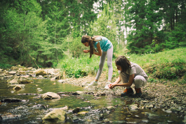 istock Kids drinking water from river in the mountains 1255210676